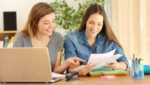 two women comparing paperwork