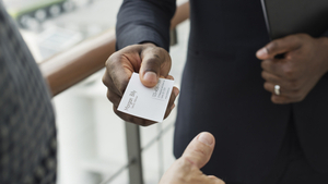 person handing a business card to another